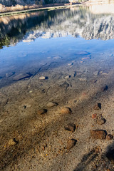 lake bed through transpatent water with reflections and shadows