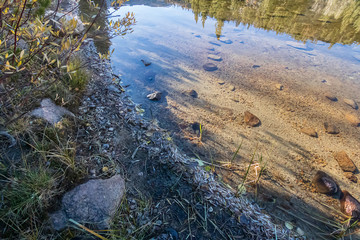 lake bed through transpatent water with reflections and shadows