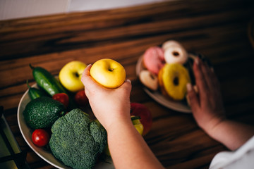 Choosing healthy eating. Cropped portrait of overweight woman eat healthy food refusing junk snacks...