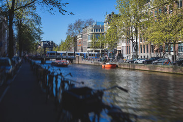 Fototapeta premium View of Amsterdam street in the historical center, with canal houses in the capital city of Amsterdam, North Holland, Netherlands, summer sunny day