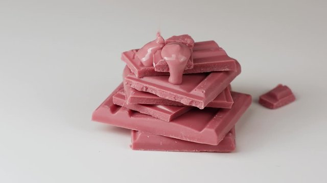 Melted ruby chocolate pouring into a piece of chocolate bars 