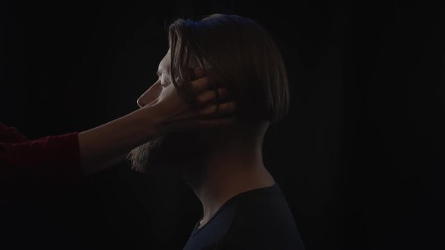 Hands of woman touching man's beard, slow motion