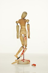 A damaged wood man standing alone with blood stains.