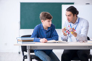 Young male teacher explaining molecular model