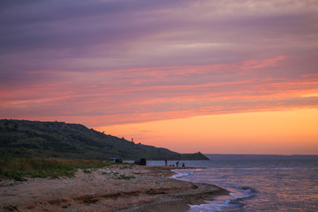 Fishermen on the beach at sunset