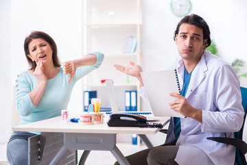 Middle-aged woman visiting male doctor stomatologist