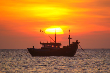 Fishing boat in the background of a huge sunset