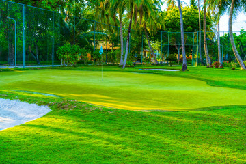 Obraz premium Golf course putting green with flag in autumn colors