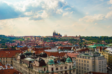 Prague rooftops cityscape skyline as seen from Prague's Old Town Hall Tower. St. Vitus cathedral is visible in the far background.
