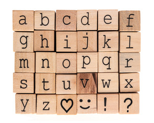 Alphabet wood blocks. Complete English lowercase alphabet in black typewriter font. Plus heart shape, simile face, exclamation mark and question mark. Isolated on white. 