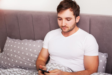 Man addicted to his mobile phone in bed