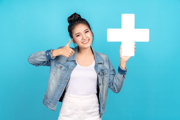 Happiness asian woman smiling, showing plus or add sign and thumb up or like on blue background....