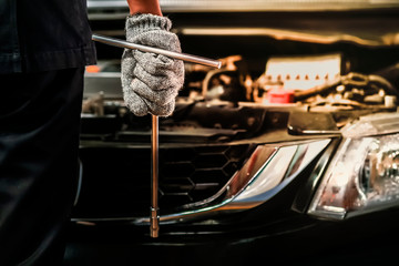 Close up, Service car is People are repair a car Use hand a wrench and a screwdriver to work.Engine repair technicians are hold the wrench in order to repair the car.Image is tone.