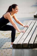 Fitness woman doing workout standing in a stadium background