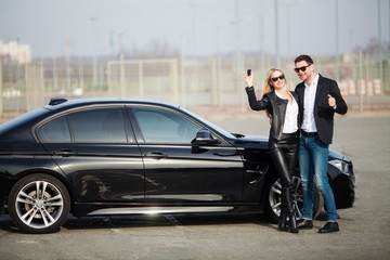 Fototapeta na wymiar Happy couple buy new modern black car
