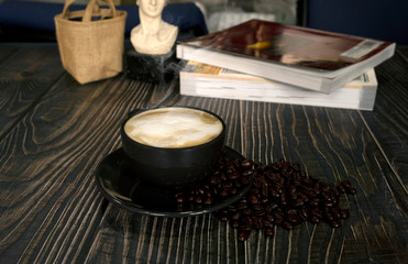 Hot latte coffee with roasted coffee beans on a wooden table