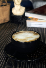 Hot latte coffee with roasted coffee beans on a wooden table