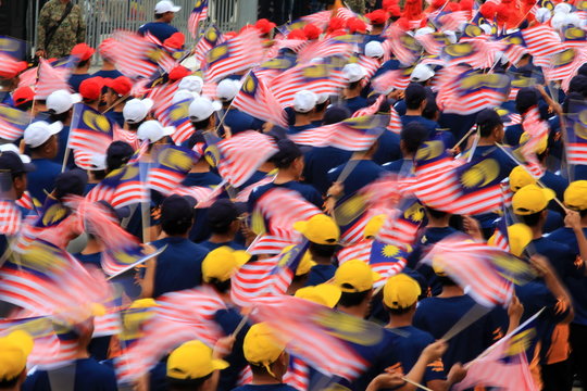 Group Of People Holding Malaysian Flag During Parade