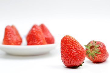 Strawberries in a white porcelain plate on a white background