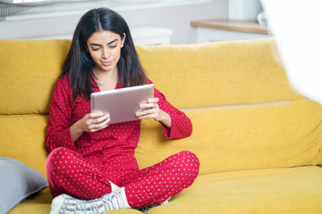 Persian woman at home using digital tablet