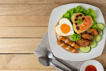 American fried rice with cucumber and lettuce in white dish on wooden table.