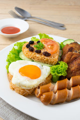 American fried rice with cucumber and lettuce in white dish on wooden table.