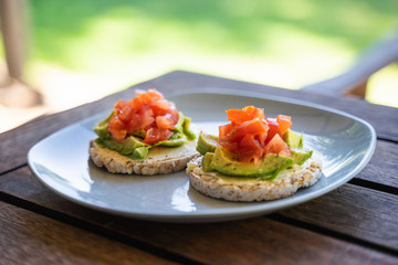 Healthy rice crackers snack with fresh avocado and tomato