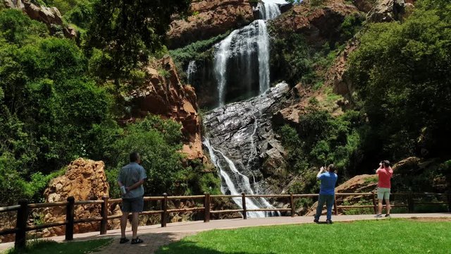 Visitors taking selfie photos near waterfall at the walter sisulu national botanical gardens in roodepoort, South Africa.