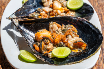 Raw clam meat in a large seashell served for food at a local restaurant on the island of Zanzibar, Tanzania, East Africa