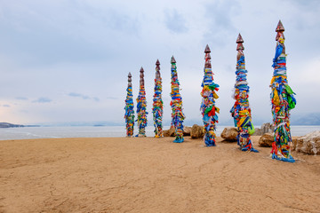 Shamanistic wooden ritual totems with colorful ribbons at Cape Burhan, Baikal, Olkhon Island, Siberia, Russia