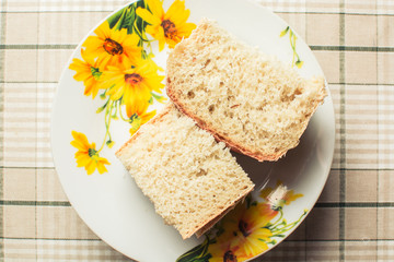 Sliced white bread in small plate on kitchen table.