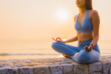 Portrait young asian woman do meditation around sea beach ocean at sunrise