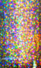 Fototapeta na wymiar Blurry bokeh with bright colors from glittering materials and lights.