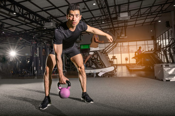 Fitness man doing a weight training by lifting heavy kettlebell