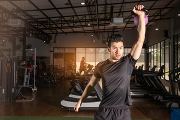 Fitness man doing a weight training by lifting heavy kettlebell