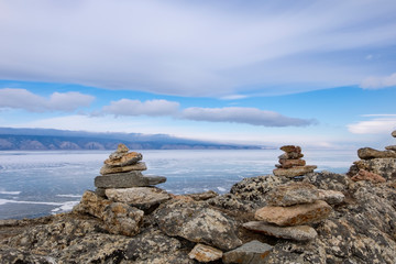 Zen-style stone pyramid on Baikal winter lake.