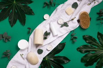 Eco organic cosmetic on green background for lifestyle design. Natural beauty cosmetics concept. Top view, flat lay. Face skin care. Spa concept. Female hand with cream