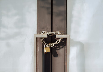 Close up old door locked with chain and padlock