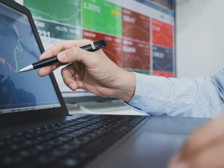 trader use computer explan about  forex and cryptocurrency data and bar chart, invester concept.