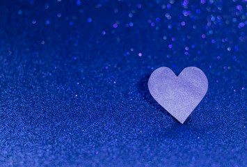 Fototapeta premium Blue heart on a blue shiny background. Monochrome photography.