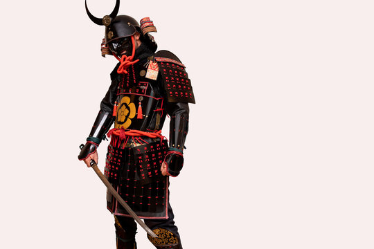 warrior with a black samurai armor posing with a white background