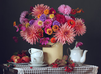 autumn still life with a bouquet, fruit, berries and white tea utensils.