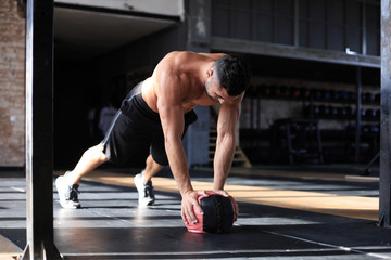 Fototapeta premium Fit and muscular man exercising with medicine ball at gym.