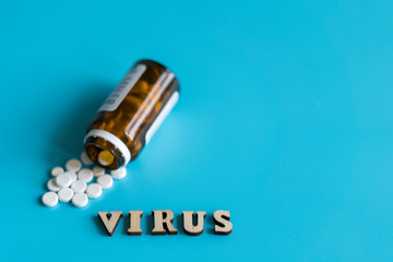 Virus treatment concept. Pills and the inscription virus on a blue background. copy space