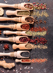 Spices and herbs over black stone background. Top view with free space for menu or recipes