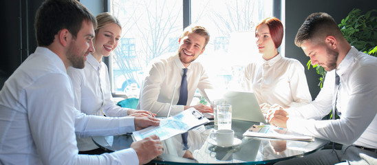 Group of business partners discussing ideas and planning work in office.