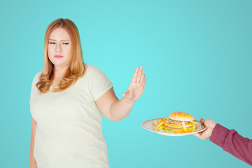 Overweight woman refusing to eat junk food