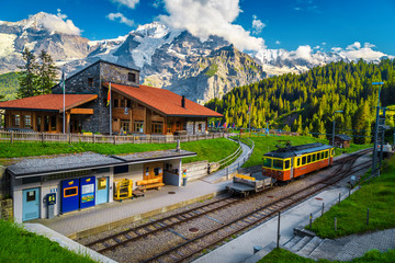 Railway station with mountains and retro tourist train, Murren, Switzerland