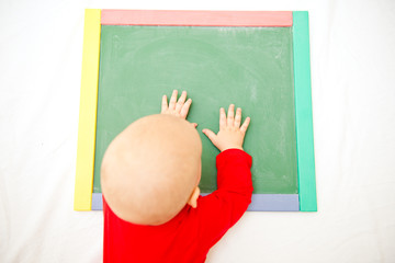 Cute baby playing with blackboard. Development and training concept