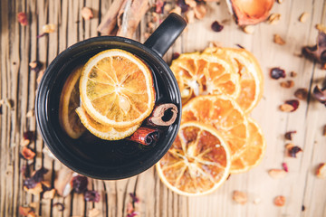 Fruit tea with cinnamon and dried berries in cup - teacup on wooden table. Top view,